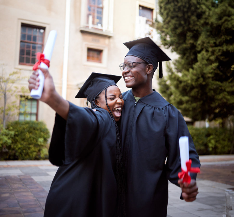 Black students, hug and celebrate for graduation, education and achievement on university, campus and success. African American woman, man or academics with smile, embrace or joy for college degree
